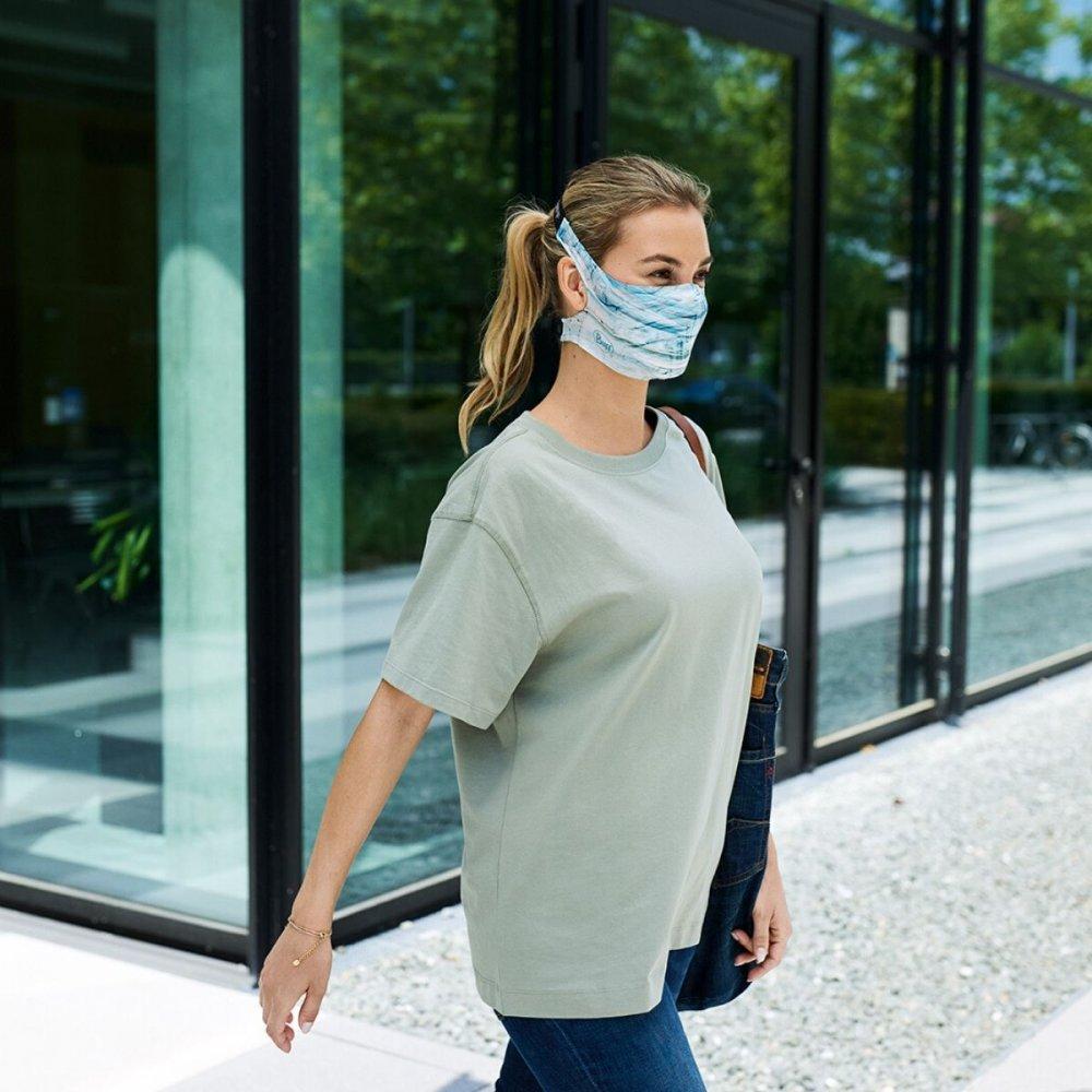 A woman wearing a Buff Filter Mask in Makrana Blue Sky