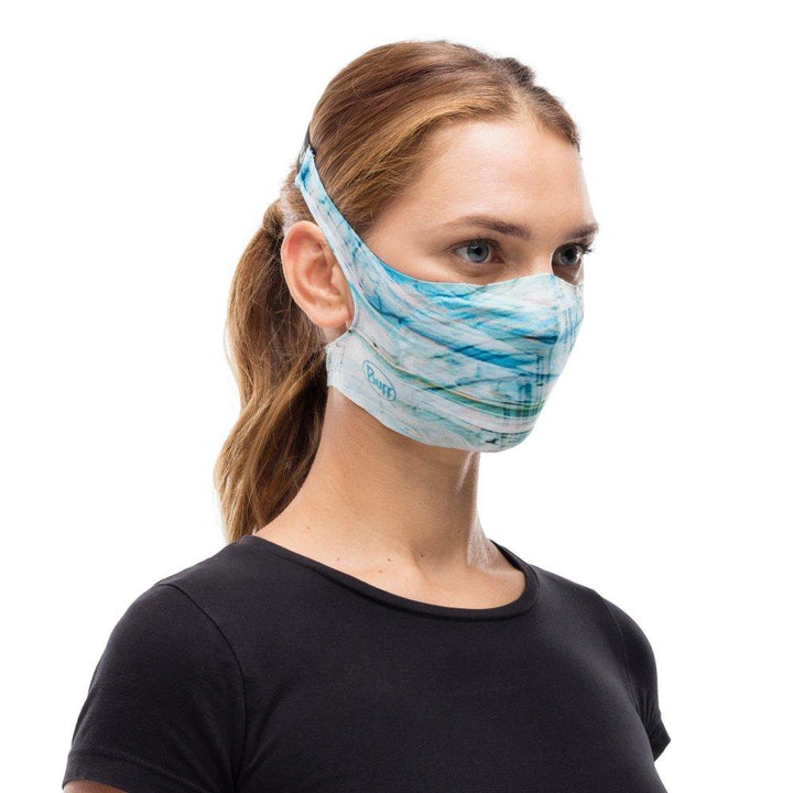 A woman wearing a Buff Filter Mask in Makrana Blue Sky