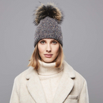 A woman wearing a Chaos New England Pom Beanie in Dark Brown